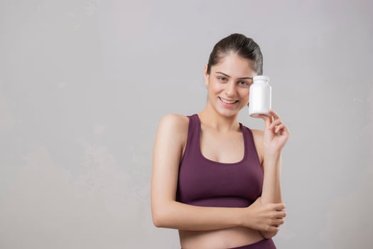 Close Up Of An Attractive Woman Holding A White Tablet Bottle photo
