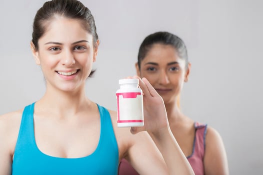 Close Up Of Two Pretty Mature Ladies Standing One Of Whom Is Holding A Tablet Bottle photo
