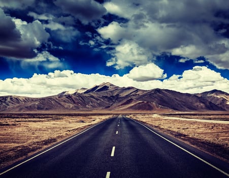 Road on plains in Himalayas with mountains photo