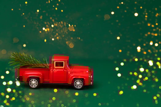 Red toy truck with Christmas fir branch in its trunk. photo