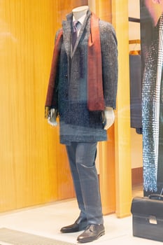 Male mannequins in a coat made of scarf on the window of a fashion store photo