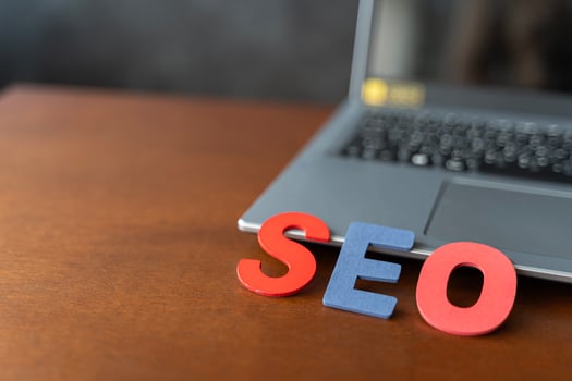 Wooden letter stands for SEO abbreviation lying on laptop at desk. Modern marketing buzzword SEO - Search engine optimisation. photo