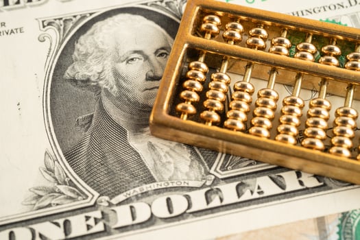 Gold abacus on US dollar banknote money, economy finance exchange trade investment. photo