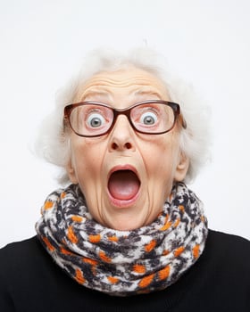 An elderly woman shows sheer surprise with wide eyes and an open mouth photo