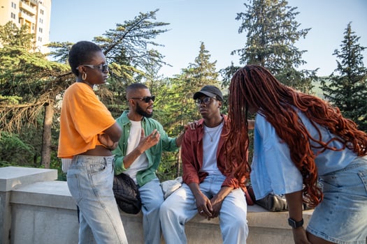 Sympathetic participating black friends students sitting together at park cheering on sad guy buddy. photo