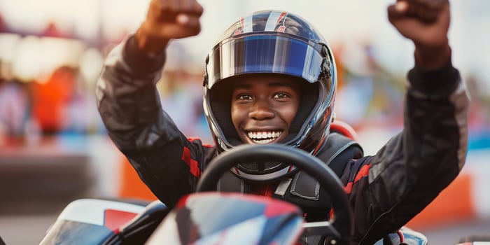 Joyful Young Racer Celebrating Victory in GoKart Race on a Sunny Day at the Karting Track photo