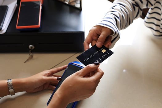 Close Up Female Customer Paying with Black Credit Card photo