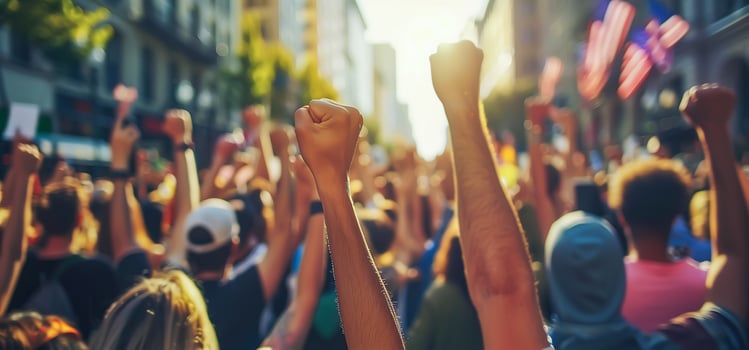 A group of protesters raise their fists in the air. . photo