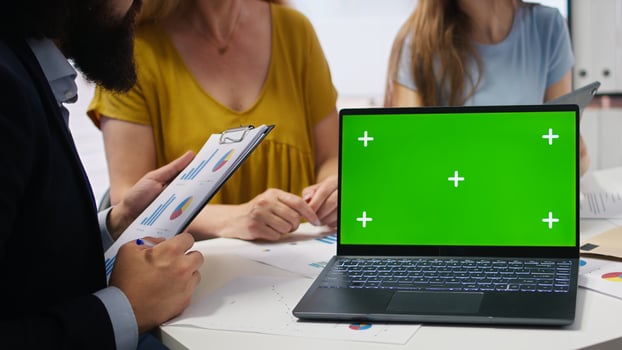 Clients looking over personalized planning guide on green screen laptop written by financial advisor during meeting. Consultant optimizing living expenses for customers using mockup notebook, camera A photo
