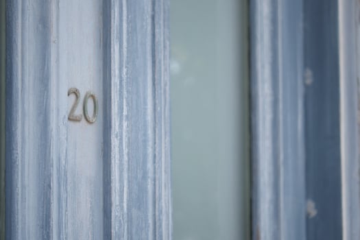 A closeup view of a beautifully designed Blue Door featuring the Number 20 prominently displayed photo