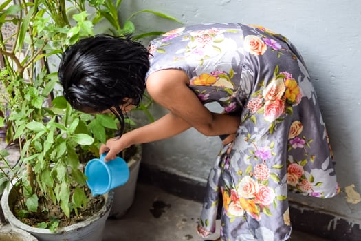 Cute 5 year old Asian little girl is watering the plant in the pots located at house balcony, Love of sweet little girl for the mother nature during watering into plants, Kid Planting photo