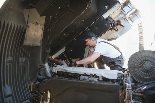 Man in uniform. Truck repair. Car malfunction photo