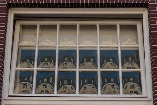 A window with a reflection of a building photo