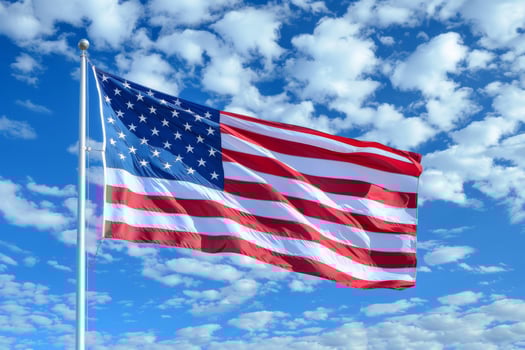 American flag on a blue sky background in close-up. The US flag is fluttering in the wind. photo