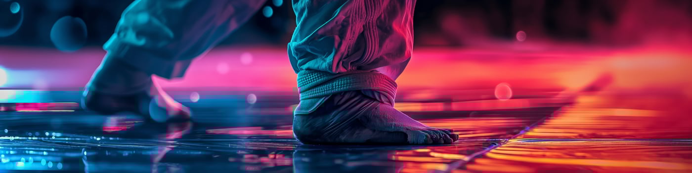 Martial Arts Training CloseUp of Barefoot Fighter in Action with Vibrant Colored Lighting photo