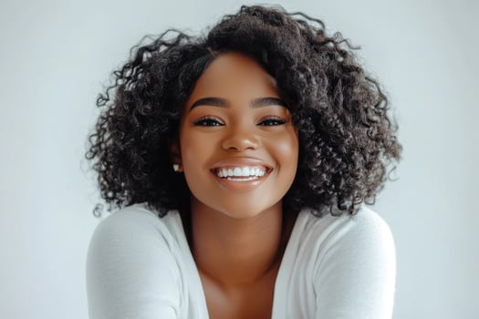 Smiling young woman with sock curls in a white studio. photo