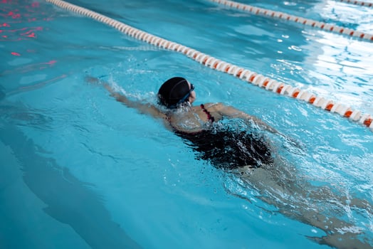 Young swimmer wears a swim cap and puts away goggles photo