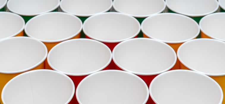 Multicolored disposable paper cups for drinks. photo