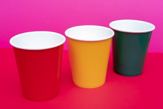 Multicolored disposable paper cups for drinks. photo