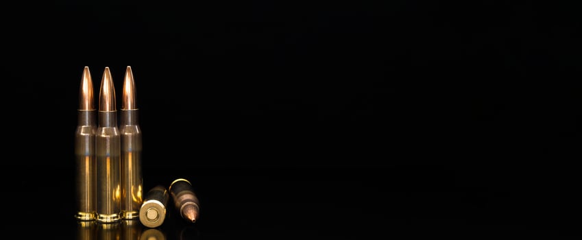 Bullet isolated on black background with reflexion. Rifle bullets close-up on black back. Cartridges for rifle and carbine on a black. photo