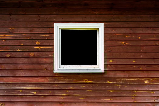 Window in the wooden wall of an old house. Brown vintage boards. photo