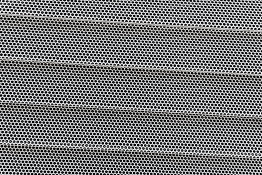 Background of wavy metallic grid with holes. Metal mesh as back. Perforated metal back. photo