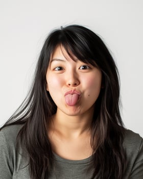 A young woman humorously shows her playful side, sticking out her tongue photo