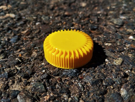 a yellow cap sits on the ground photo
