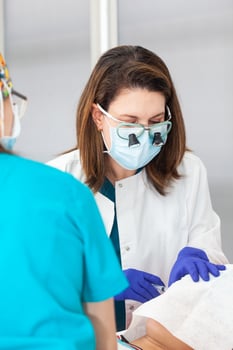 Skin lesion removal procedure. Dermatologist carrying out a removal of benign skin lesion on the face of a young male patient. Local anesthesia photo
