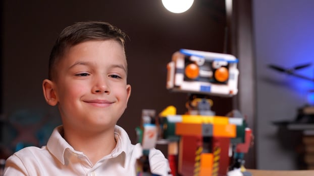 Happy child programming robot from building blocks at home photo