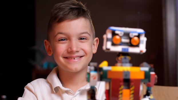 Young engineer smiling with his creation robot from constructor toy photo