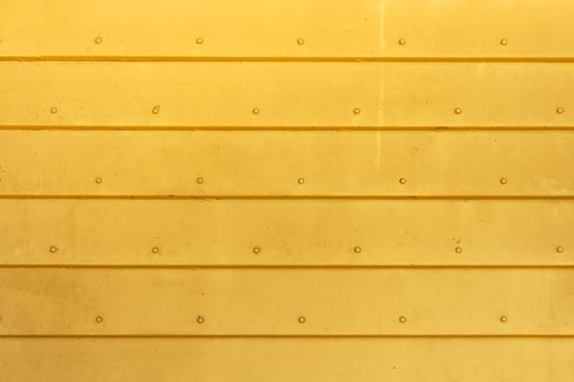 Corrugated metal background in yellow color. The texture of horizontal metal plates connected by rivets. Blank for a poster or banner. photo
