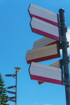 Blank directional road signs against blue sky. Directional sign post. Blue back. photo