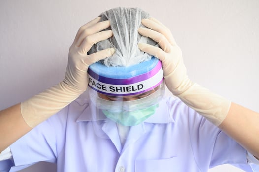 Portrait of Nurse or Doctor having headache and stress from working. The wellbeing and emotional resilience are key components of maintaining essential care services during the COVID-19 pandemic. photo