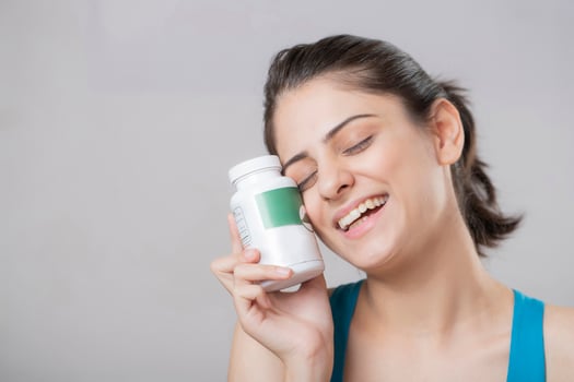 Portrait Of Pretty Woman Face While Holding Vitamin Bottle photo