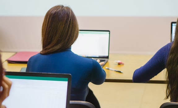 view from the back. girl sitting at a laptop photo