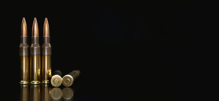 Bullet isolated on black background with reflexion. Rifle bullets close-up on black back. Cartridges for rifle and carbine on a black. photo