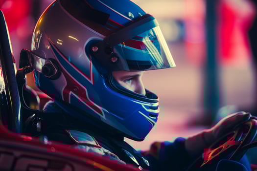 CloseUp of Racer in Colorful Helmet Driving GoKart During Nighttime Race photo
