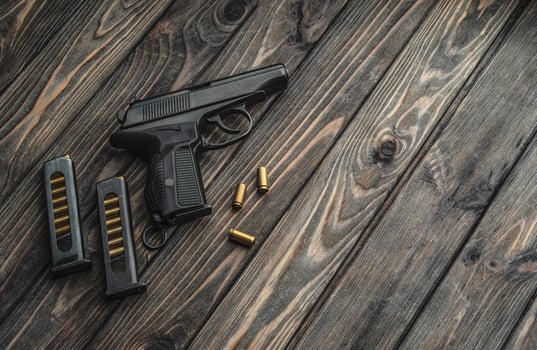 Pistol and cartridges for it on a wooden background. A short-barreled weapon for self-defense photo