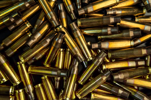 Background from empty cartridges for rifles and carbines. Shiny brass shells scattered on the surface. photo