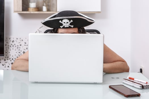 Pirate-Themed Hacker Engaging in Online Scams at a Modern Home Office photo