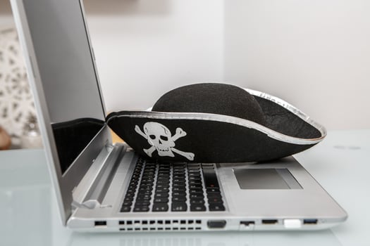 Creative Representation of Hacking and Online Scams With Pirate Hat on Laptop photo