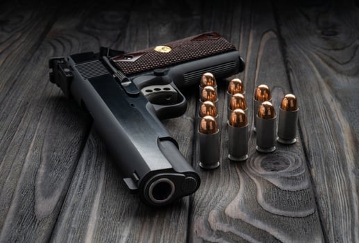 Pistol and cartridges for it on a wooden backg. A short-barreled weapon for self-defense. photo