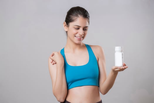 Smiling Lady Holding Dietary Supplements Container In Hand photo