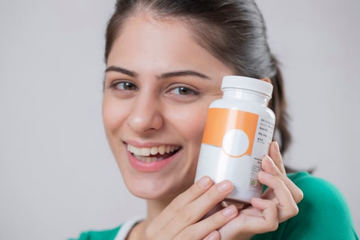 Self Assured Woman Holding Medicine Bottle In Hand photo