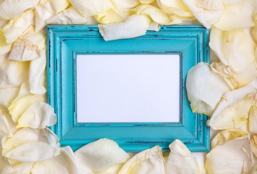 Wooden frame among the petals of roses. photo