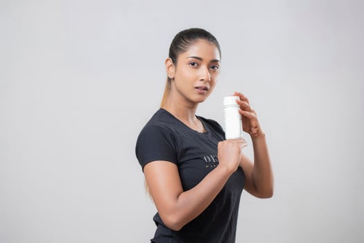 Side Pose Of Fashion Woman Holding Dietary Supplement Bottle In Hand photo