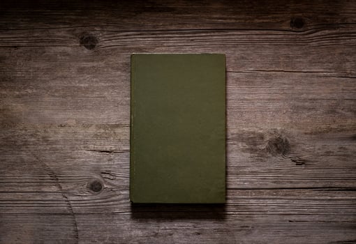 Closed book on vintage wooden background. Old book on the wooden table. Closed book with empty cover laying on wooden table. photo