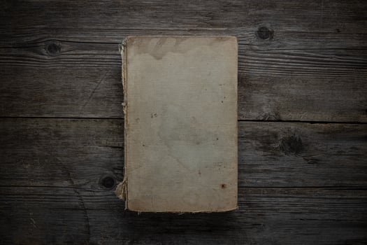 Closed book on vintage wooden background. Old book on the wooden table. Closed book with empty cover laying on wooden table. photo