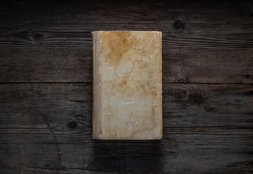 Closed book on vintage wooden background. Old book on the wooden table. Closed book with empty cover laying on wooden table. photo